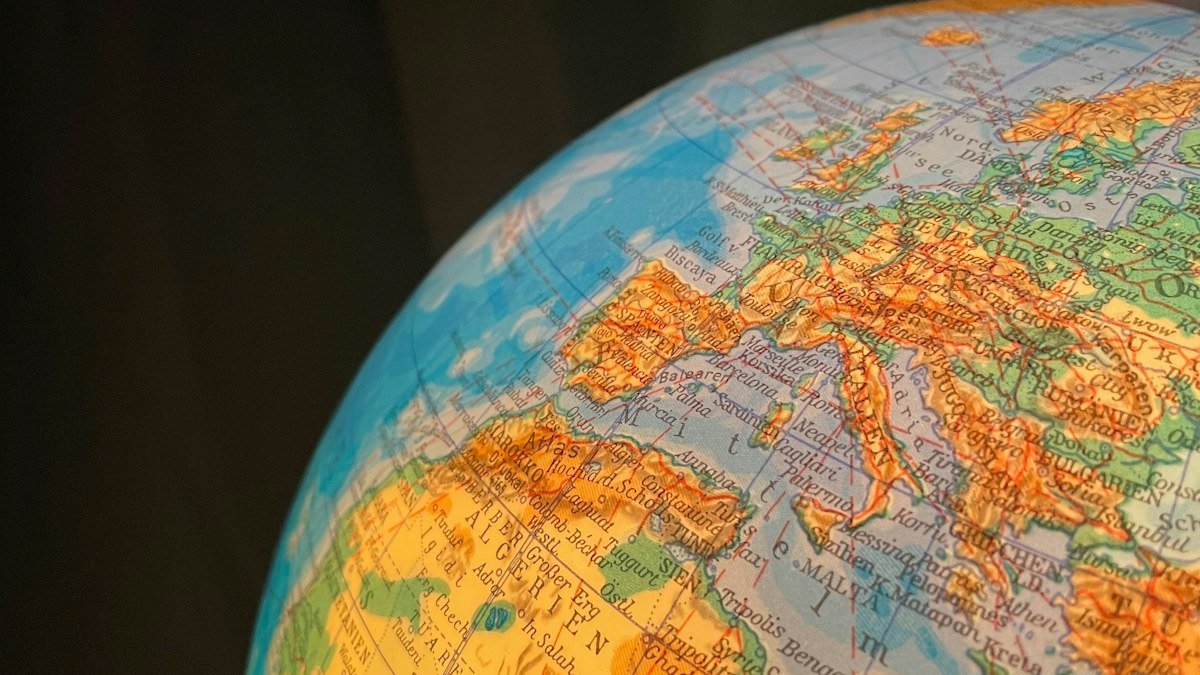 A lit-up classroom globe showing Europe and North Africa against a dark background